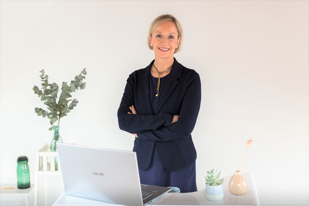 Katrin Faust Consultancy Resilienz im Business am Schreibtisch stehend